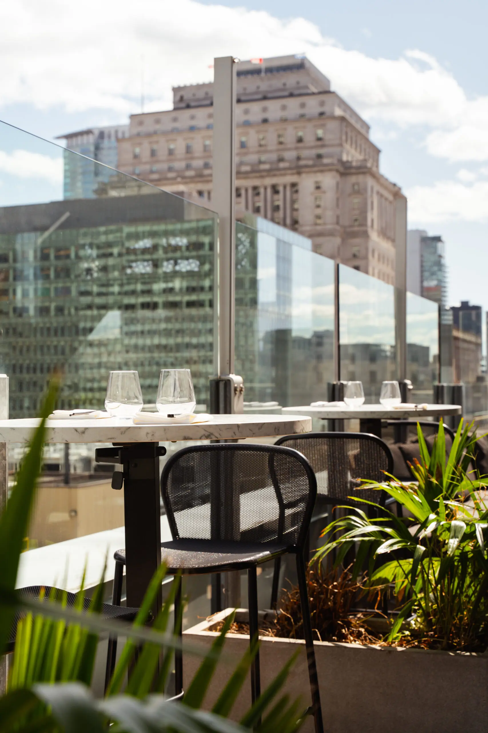 Tables sur la terrasse R avec vue sur les immeubles de Montréal