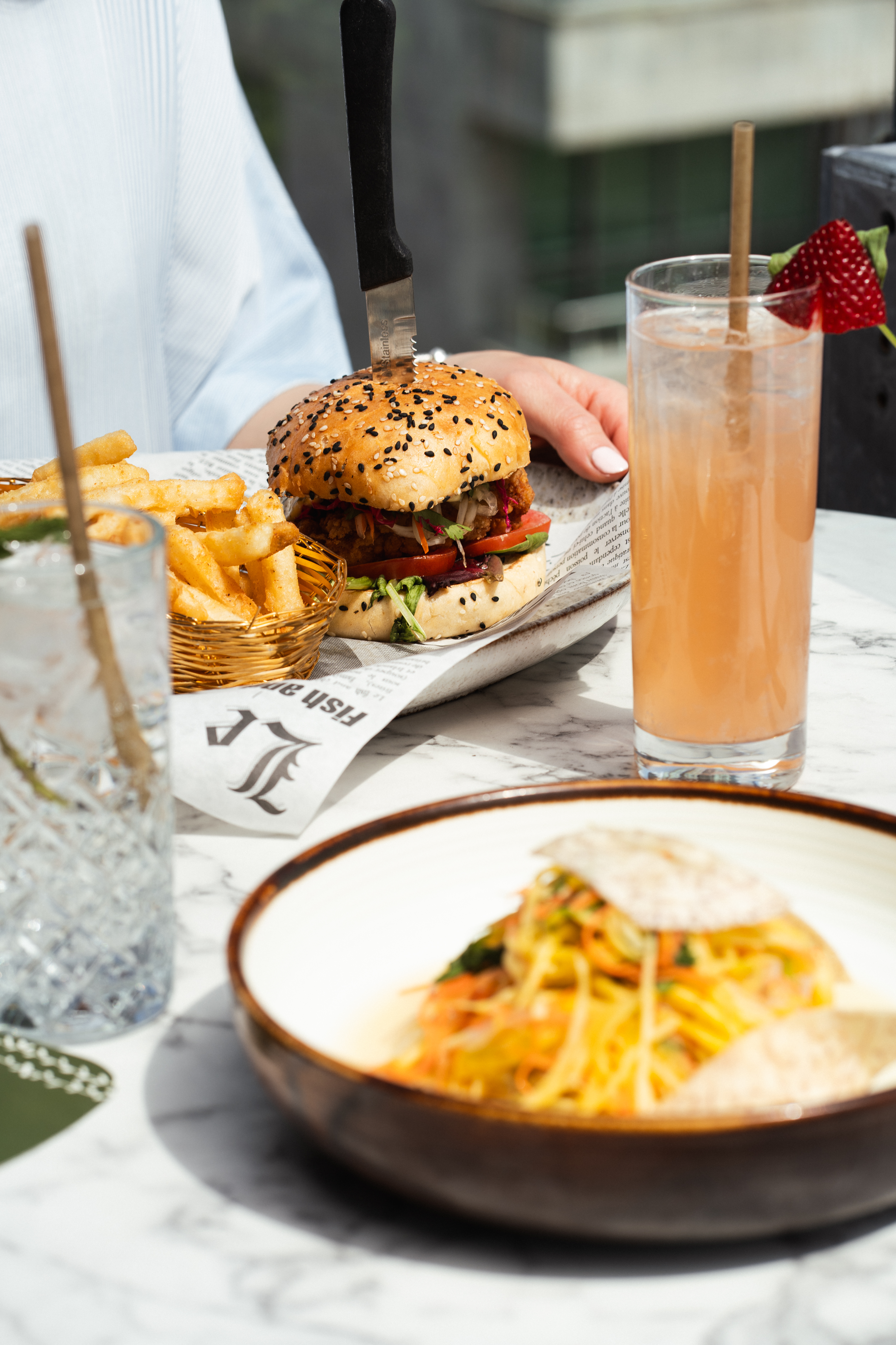 Burger avec cocktail sur une table en marbre